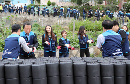 26일 부산 사상구에 있는 주택가에서 경남정보대 교직원과 학생들이 저소득가정에 연탄을 나눠주는 '사랑의 연탄 나누기' 행사를 하고 있다. 학생들은 학술제 경비를 아끼고 모금을 해서 마련한 돈으로 연탄 2천400장을 구매해 저소득층 가정 19가구에 직접 전달했다.